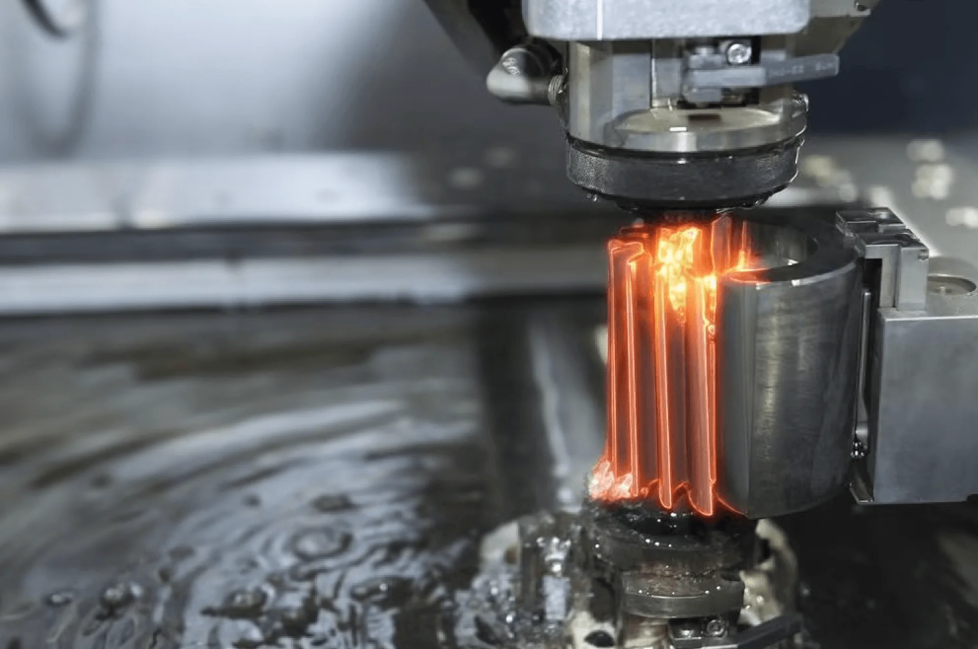 Wire EDM machine cutting a precision metal workpiece with a fine charged wire