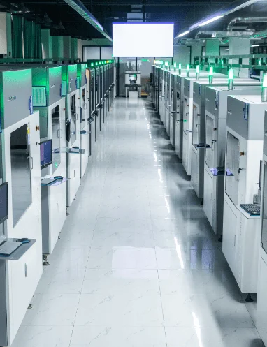 A long aisle of numerous industrial 3D printers operating in a large manufacturing hub.